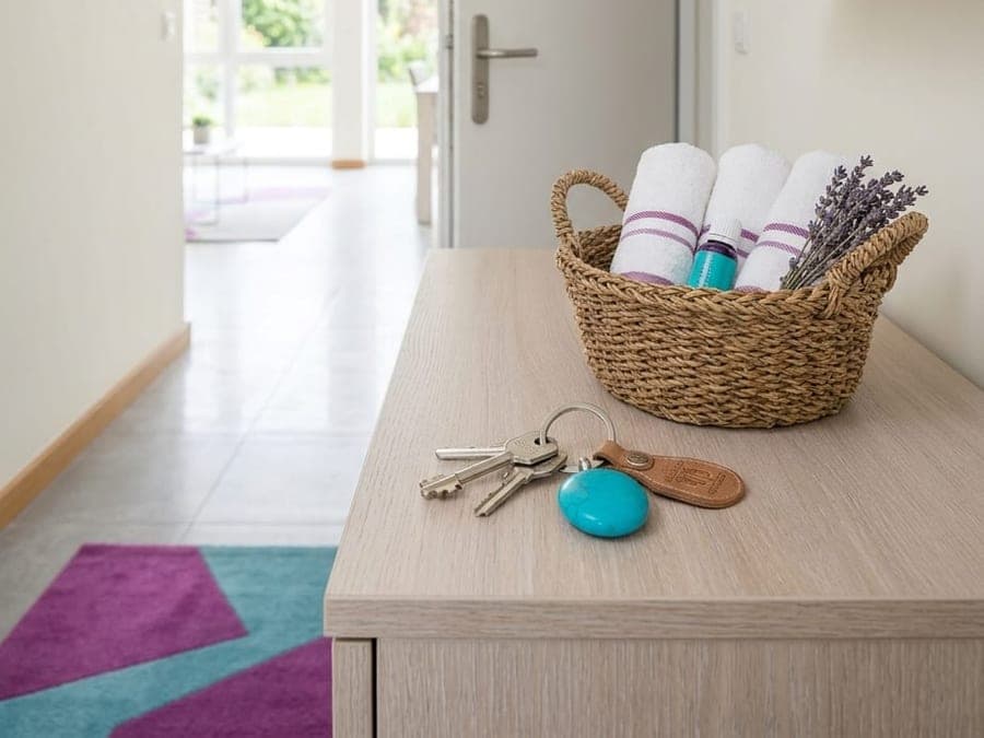 Trousseau de clés, serviettes roulées et panier d'accueil sur une console