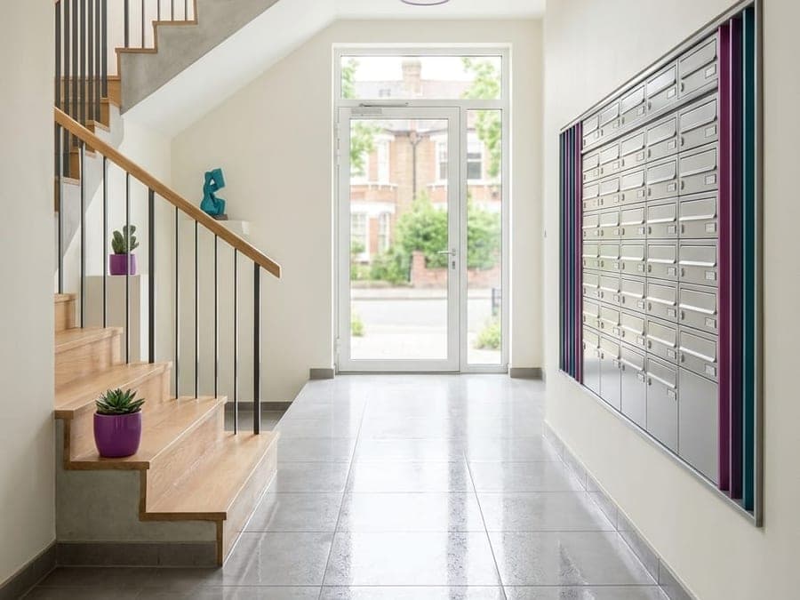 Départ d'escalier et carrelage brillant d'un hall d'immeuble