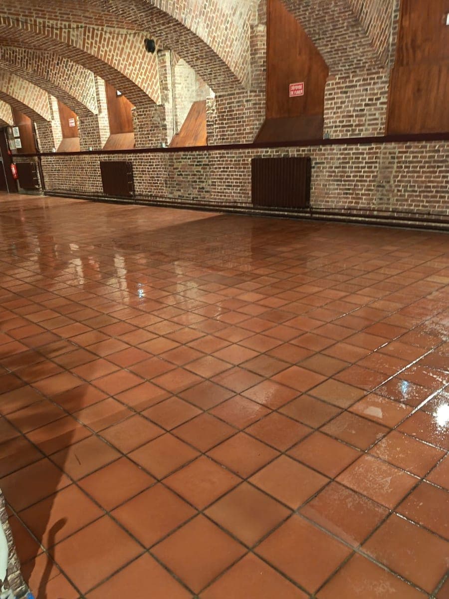Salle voûtée en briques rouges au sol de terre cuite fraîchement lavé et brillant